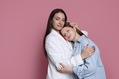 Photo of Family portrait of beautiful mother with teenage daughter on pink background