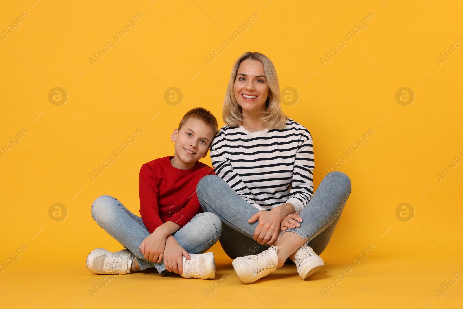 Photo of Happy mother and son on orange background