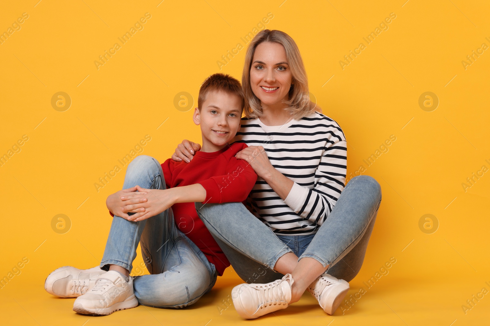 Photo of Happy mother and son on orange background