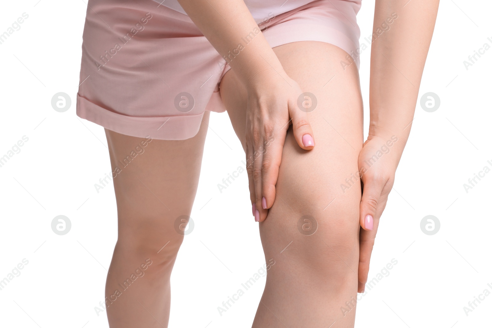 Photo of Young woman suffering from pain in knee on white background, closeup