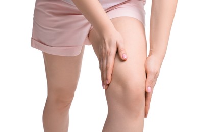 Photo of Young woman suffering from pain in knee on white background, closeup