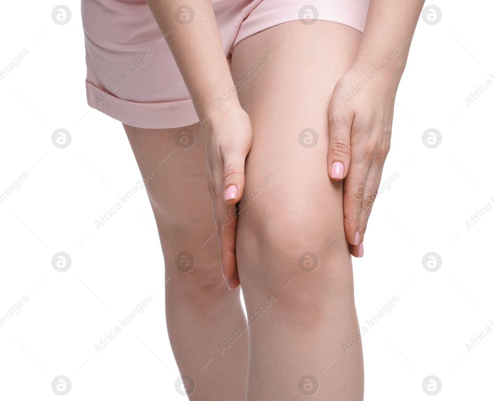 Photo of Young woman suffering from pain in knee on white background, closeup