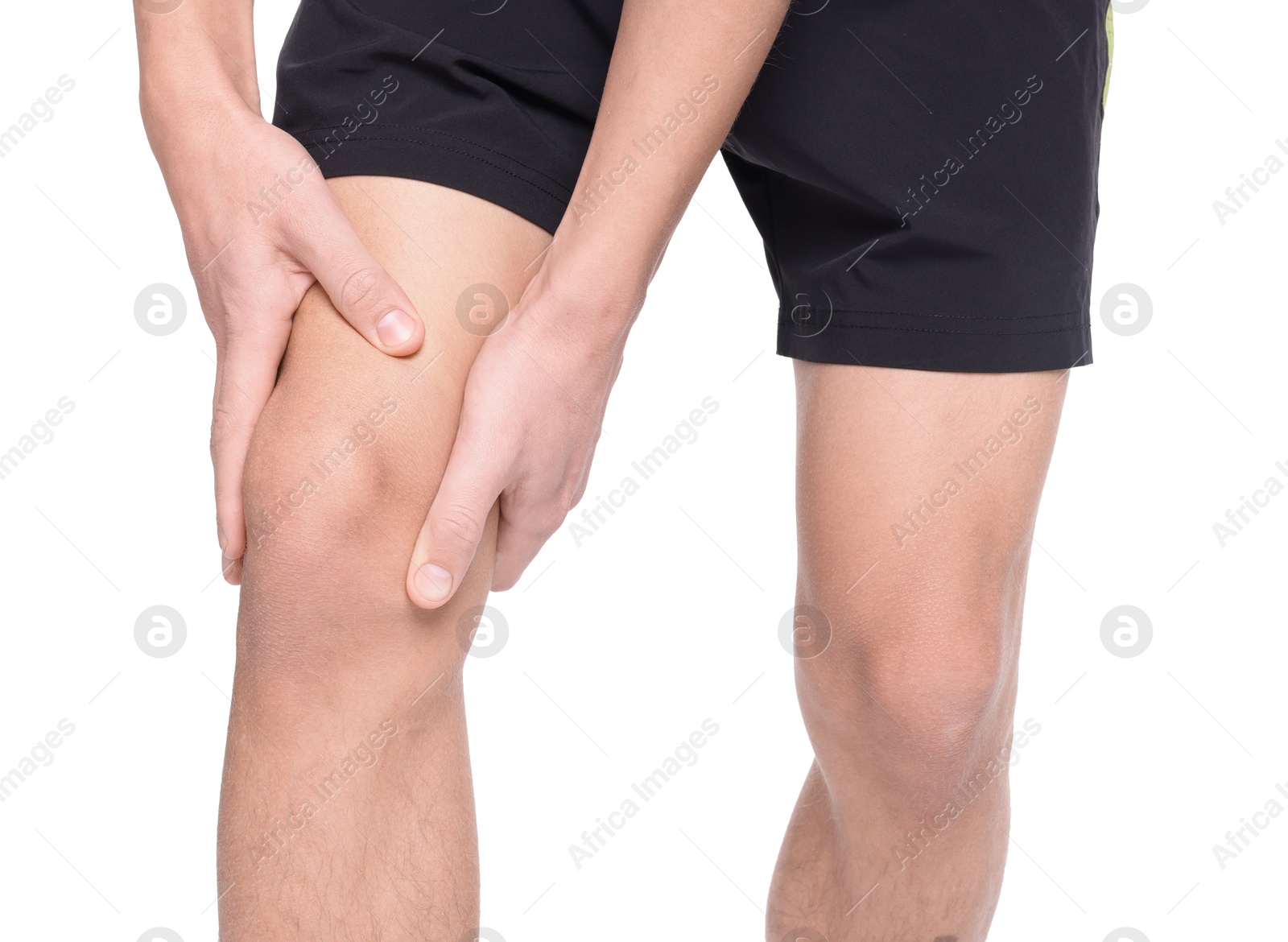 Photo of Young man suffering from pain in knee on white background, closeup