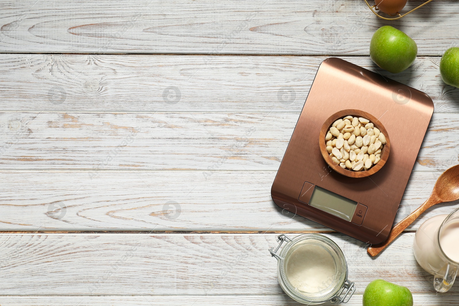 Photo of Electronic kitchen scale and products on white wooden table, flat lay. Space for text