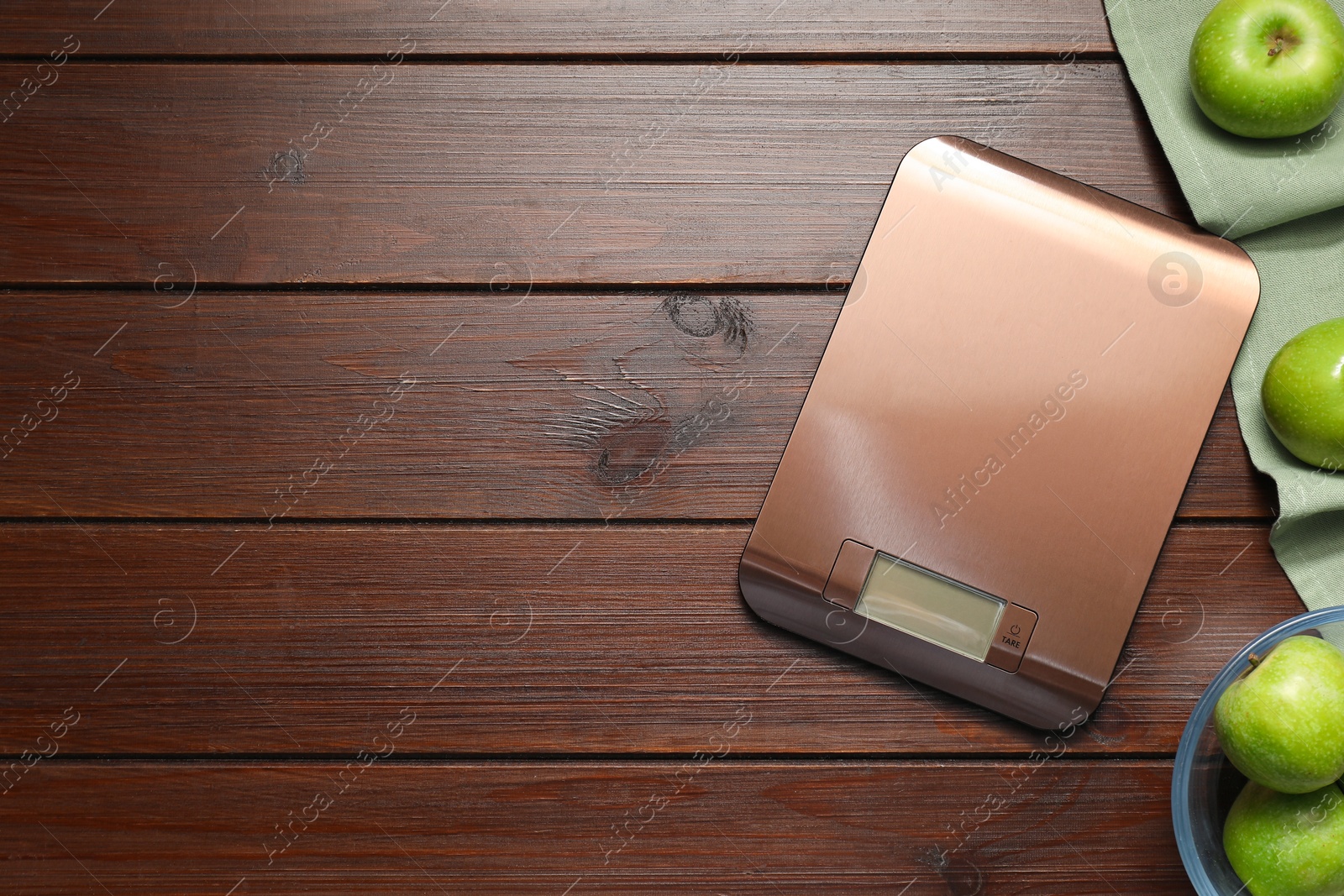 Photo of Electronic kitchen scale and apples on wooden table, flat lay. Space for text