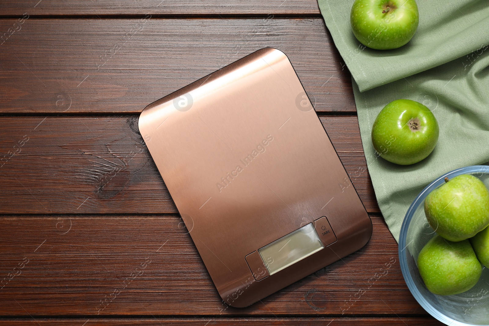 Photo of Electronic kitchen scale and apples on wooden table, flat lay