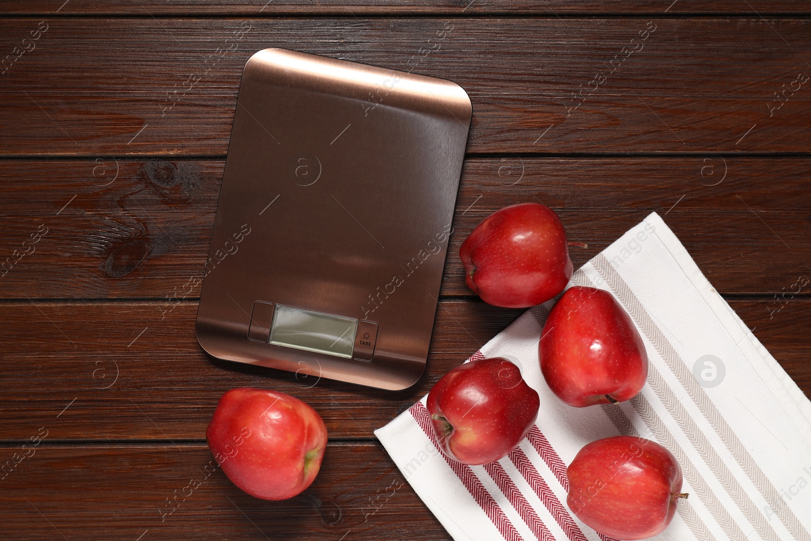 Photo of Electronic kitchen scale and apples on wooden table, flat lay