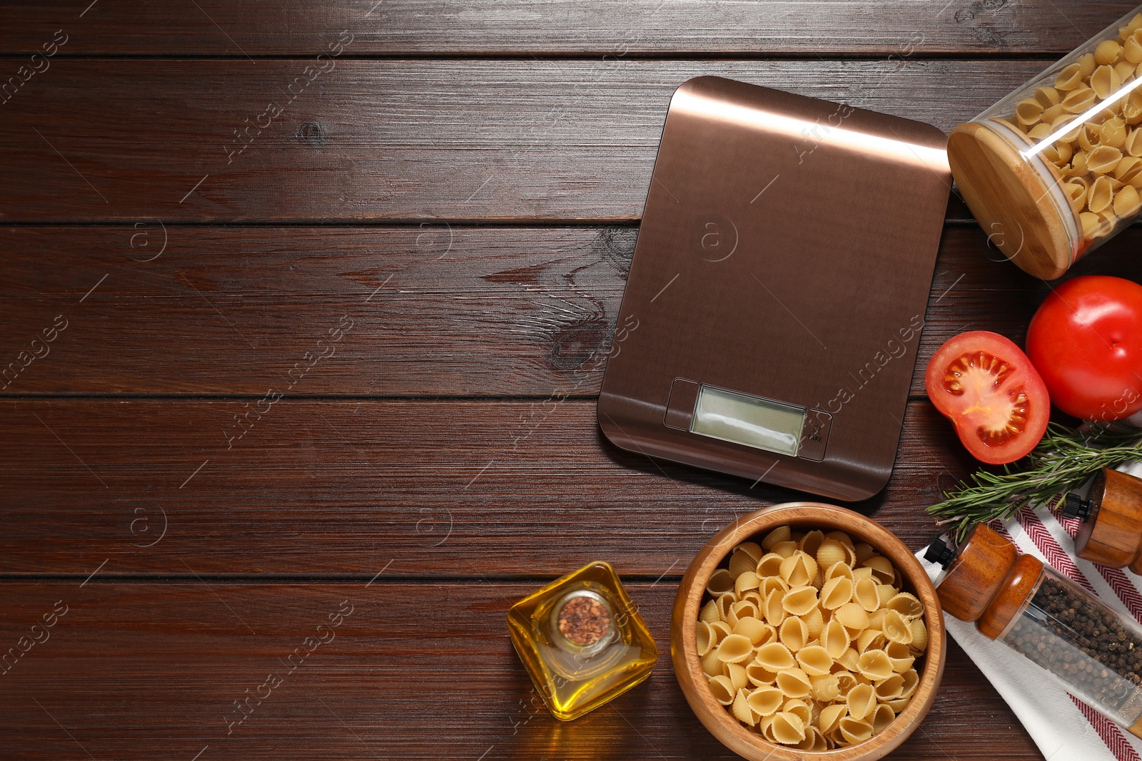 Photo of Electronic kitchen scale and products on wooden table, flat lay. Space for text