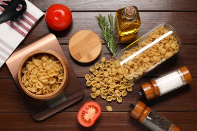 Photo of Electronic kitchen scale and products on wooden table, flat lay