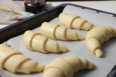 Photo of Raw croissants on white table, closeup view