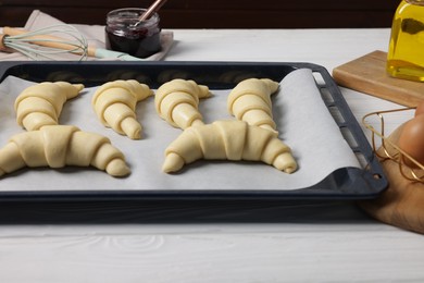 Raw croissants on white wooden table, closeup