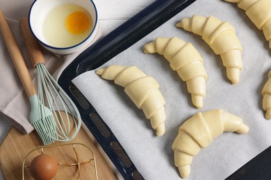 Photo of Raw croissants and eggs on white wooden table, flat lay