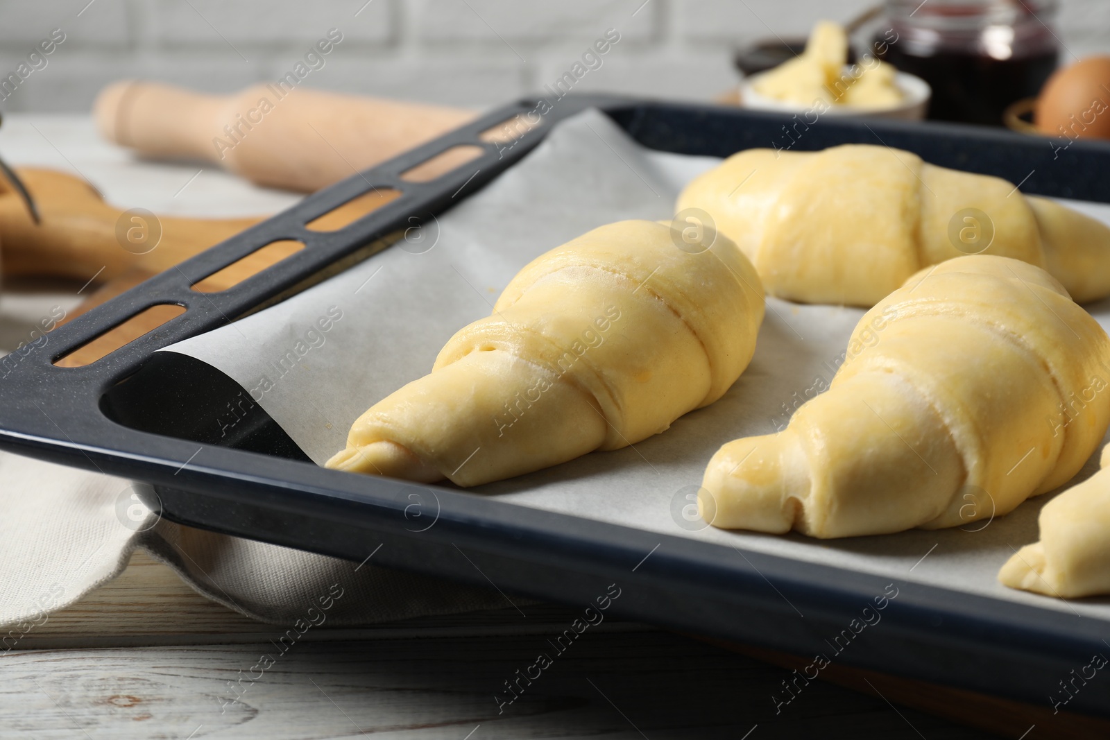 Photo of Raw croissants on wooden table, closeup view