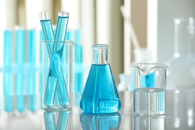 Photo of Laboratory glassware with liquid on mirror surface indoors, closeup