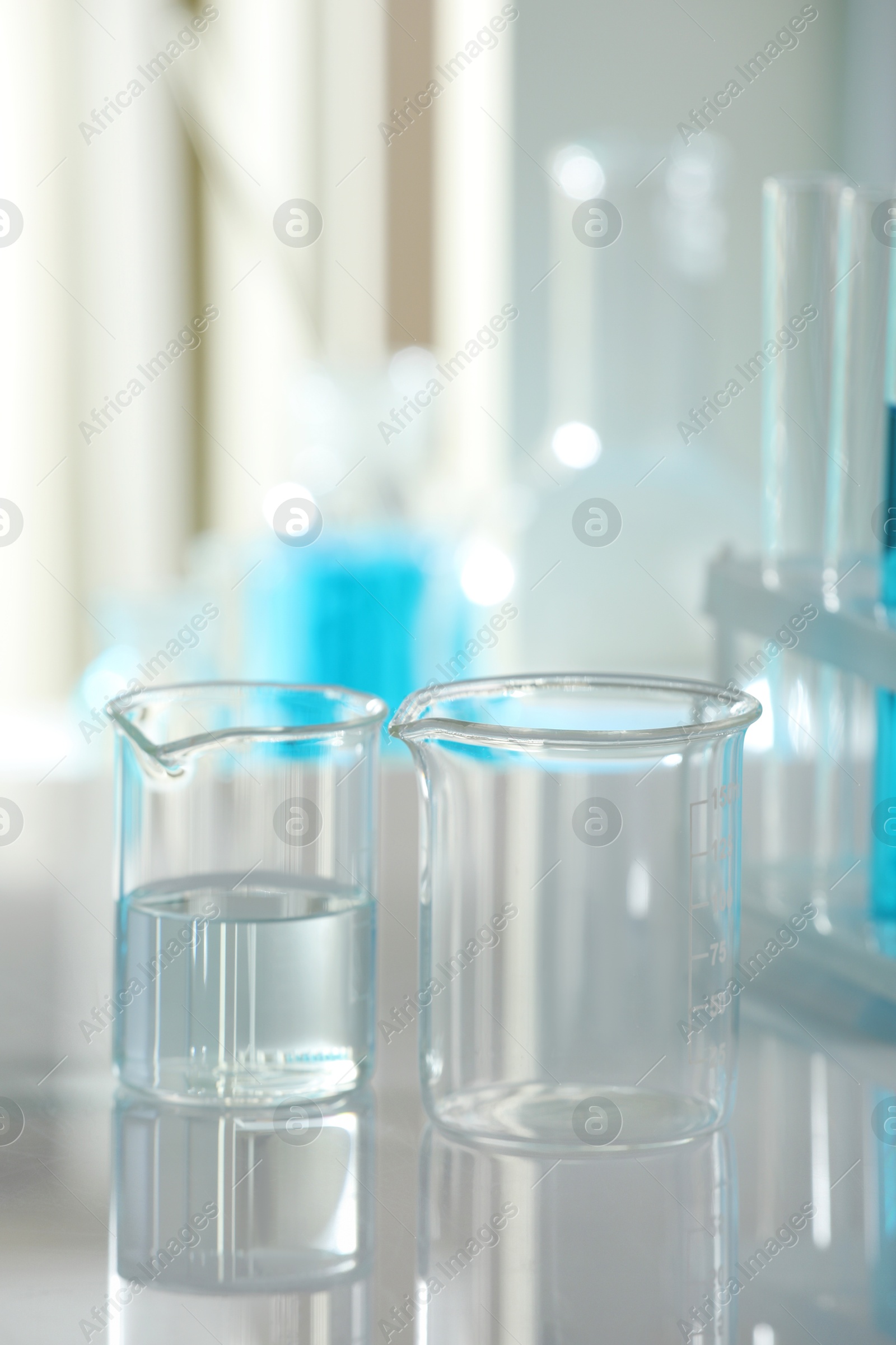 Photo of Laboratory glassware with liquid on mirror surface indoors