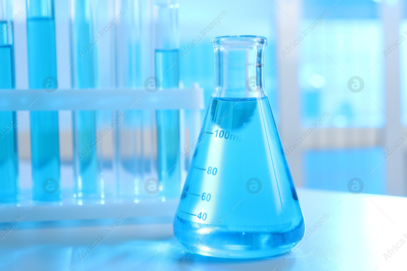 Photo of Laboratory glassware with liquid on table indoors