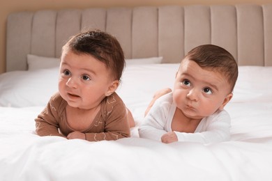 Photo of Cute twin babies resting on bed indoors