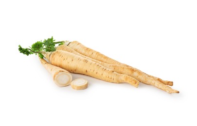 Photo of Whole and cut fresh parsley roots isolated on white