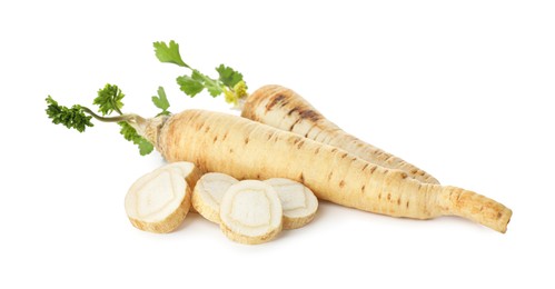 Photo of Whole and cut fresh parsley roots isolated on white