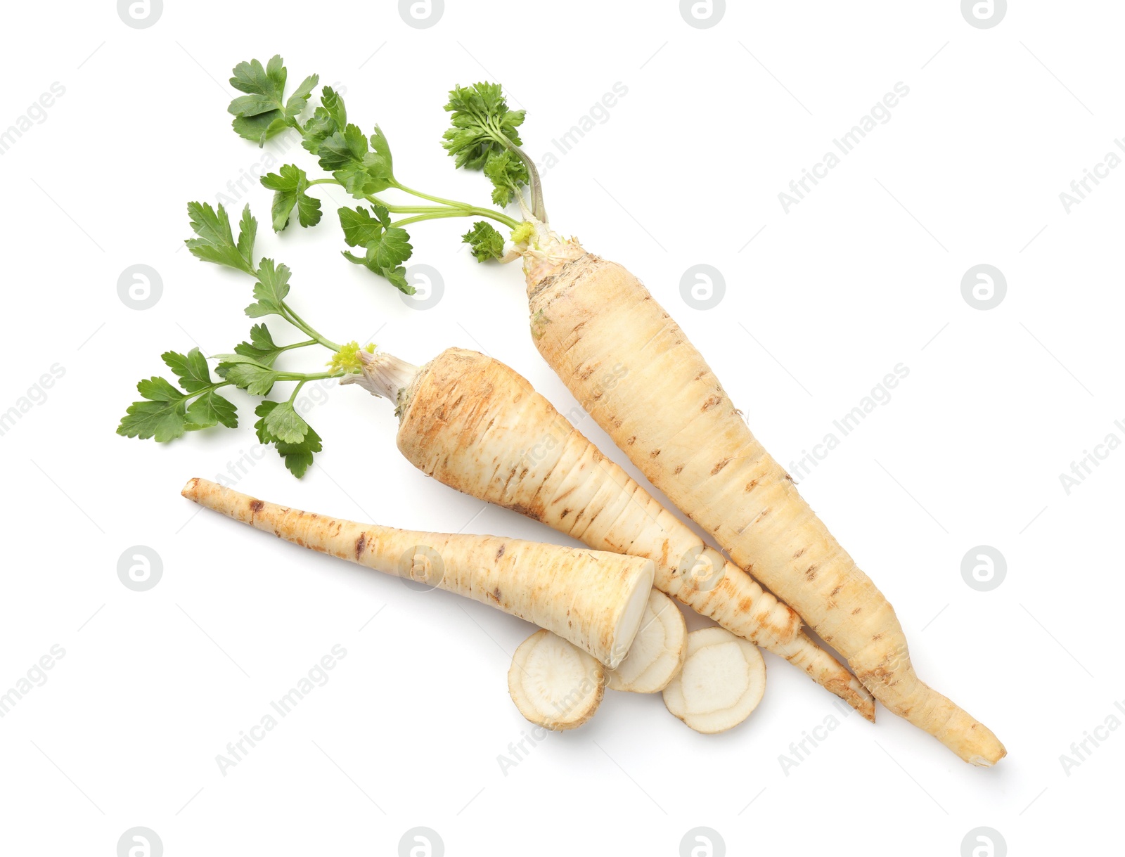 Photo of Whole and cut fresh parsley roots isolated on white, top view