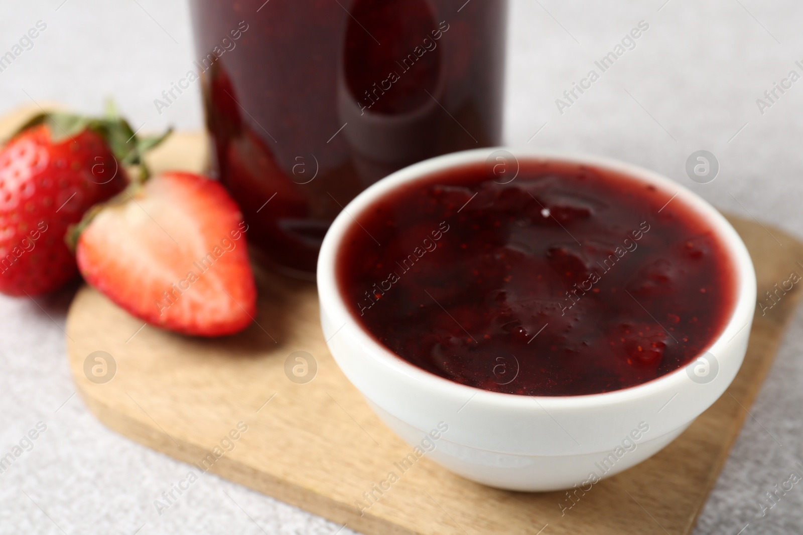 Delicious strawberry sauce and fresh berries on light table, closeup Photo of Delicious strawberry sauce and fresh berries on light table, closeup