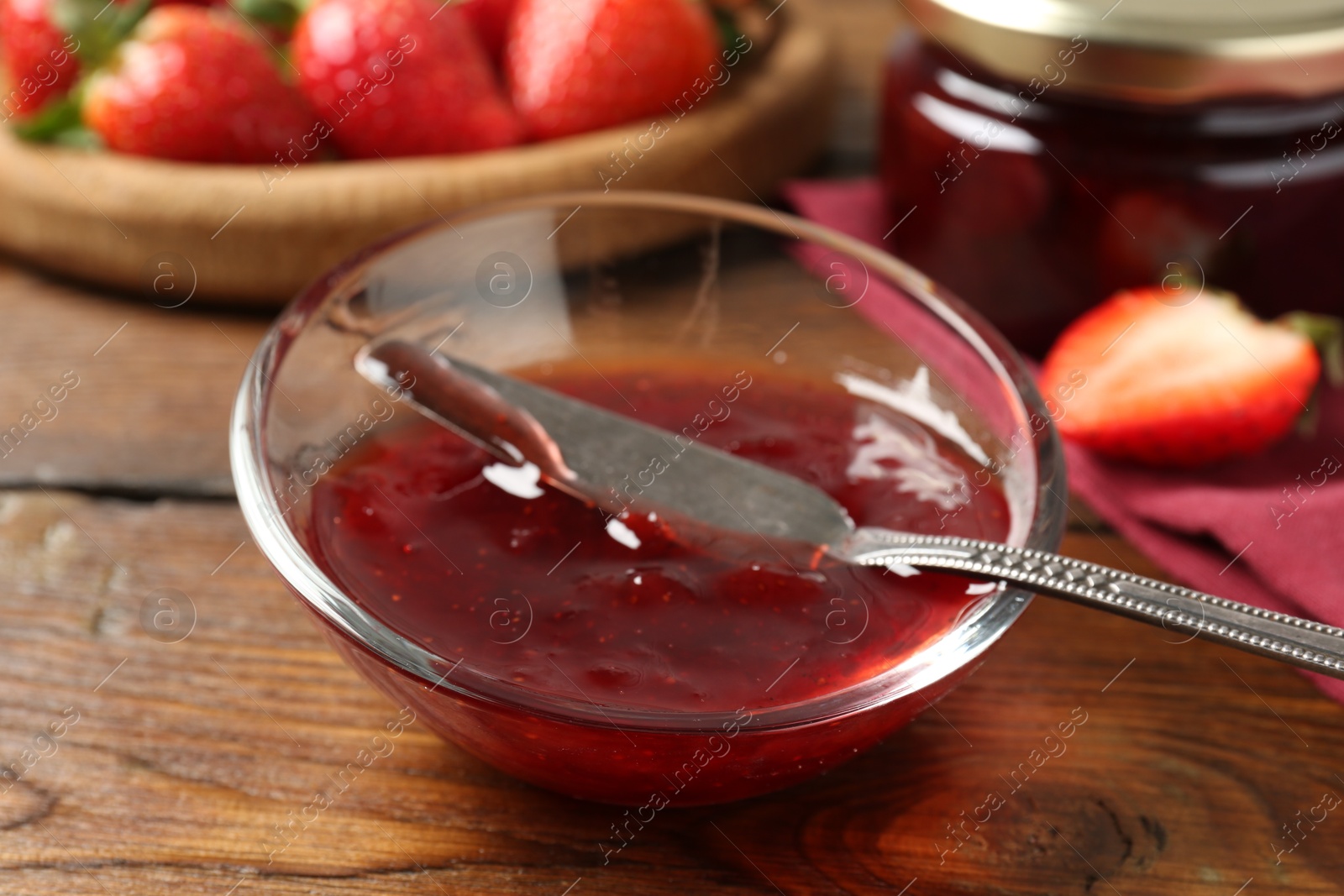 Photo of Delicious strawberry sauce and fresh berries on wooden table, closeup