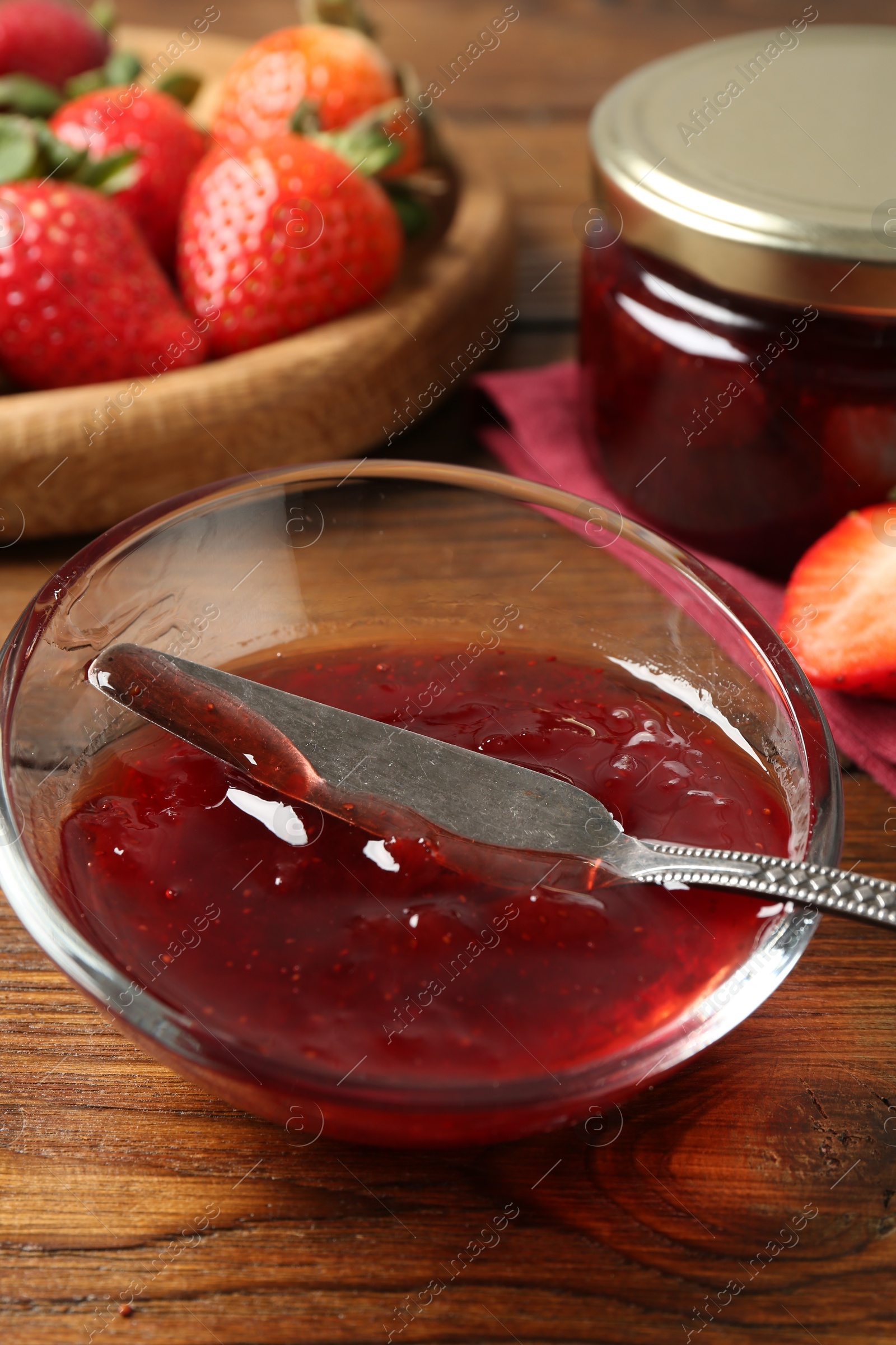 Photo of Delicious strawberry sauce and fresh berries on wooden table, closeup