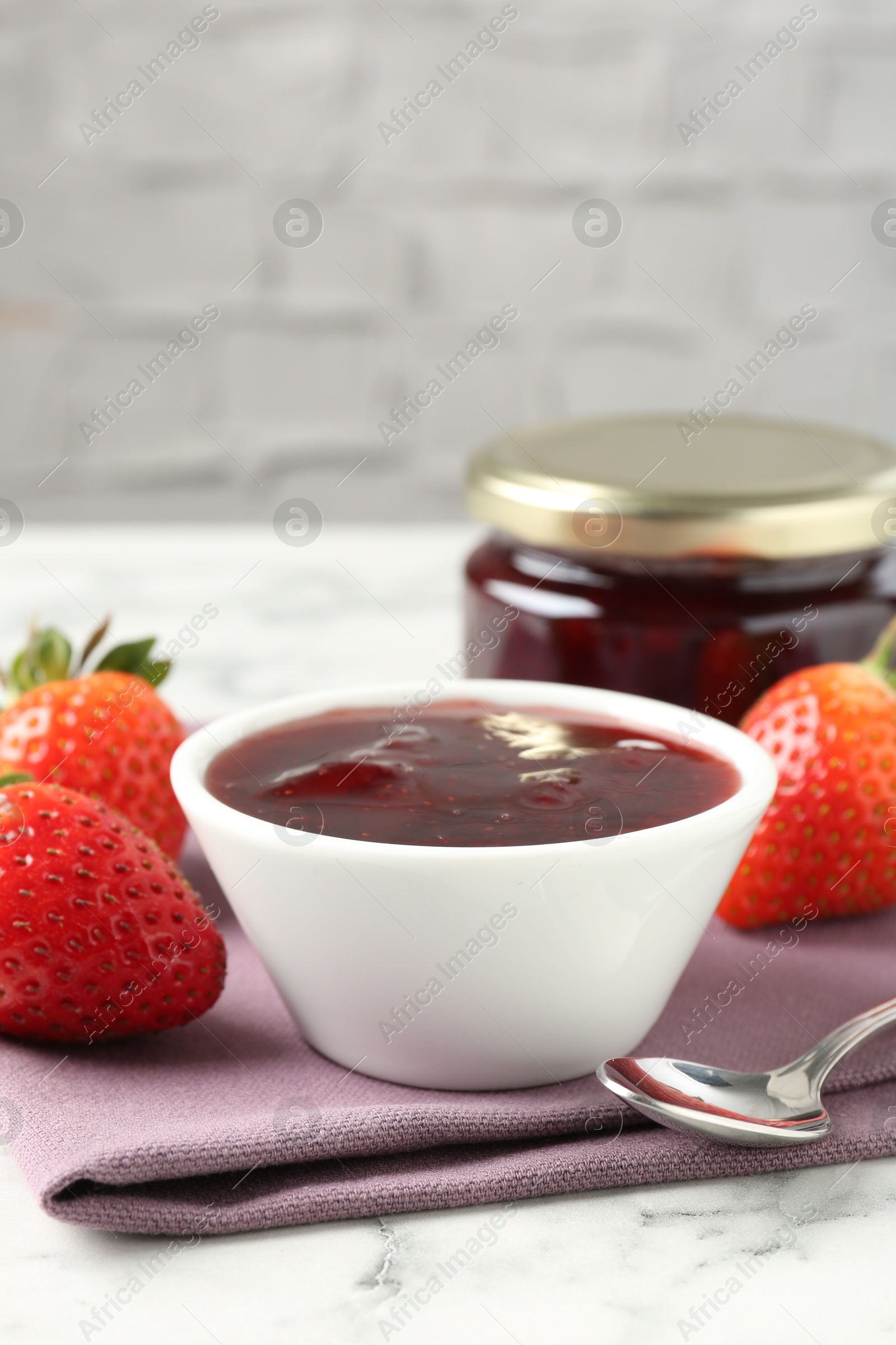 Photo of Delicious strawberry sauce and fresh berries on white marble table, closeup. Space for text