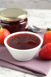 Photo of Delicious strawberry sauce and fresh berries on white marble table, closeup