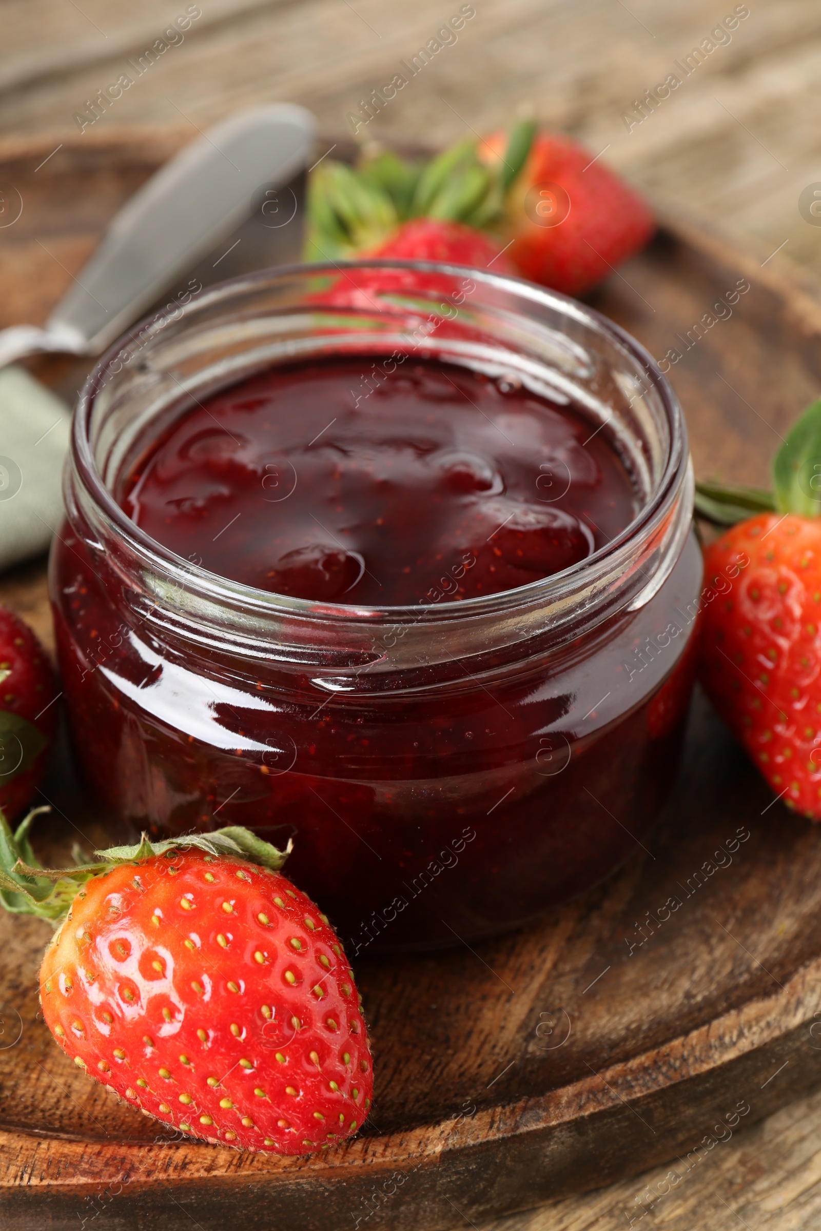 Photo of Delicious strawberry sauce and fresh berries on wooden table, closeup