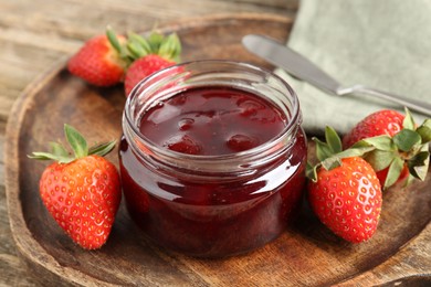 Photo of Delicious strawberry sauce and fresh berries on wooden table, closeup