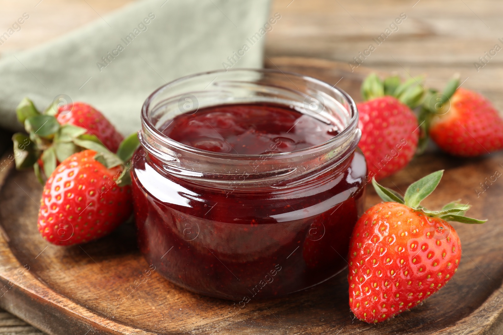 Photo of Delicious strawberry sauce and fresh berries on wooden table, closeup