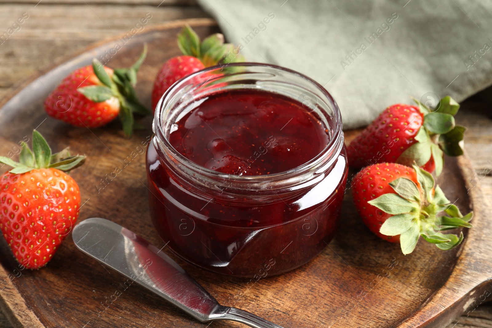 Photo of Delicious strawberry sauce and fresh berries on wooden table, closeup