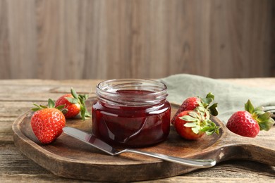 Photo of Delicious strawberry sauce and fresh berries on wooden table. Space for text