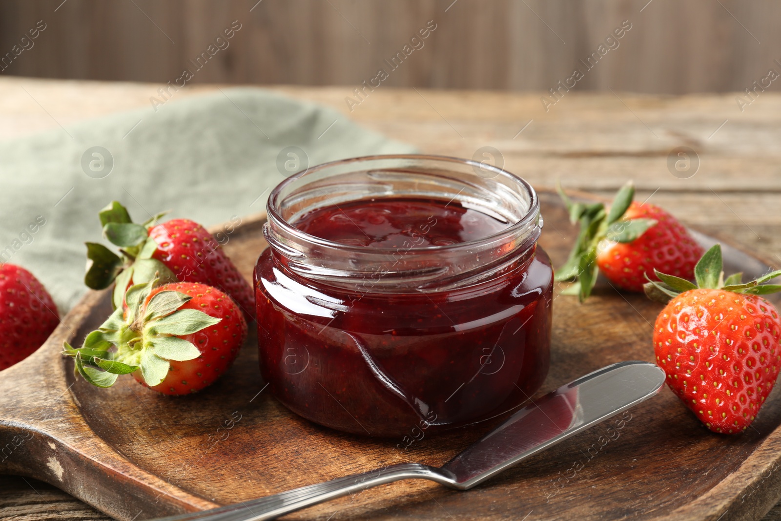 Photo of Delicious strawberry sauce and fresh berries on wooden table, closeup