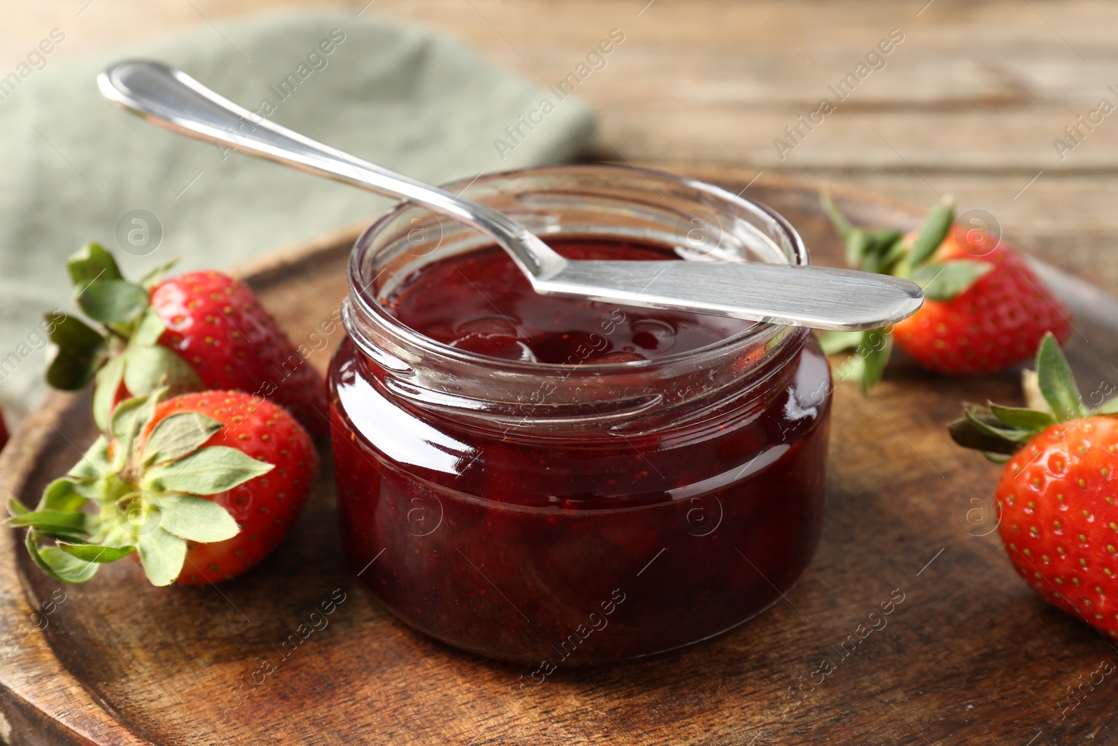 Photo of Delicious strawberry sauce and fresh berries on wooden table, closeup