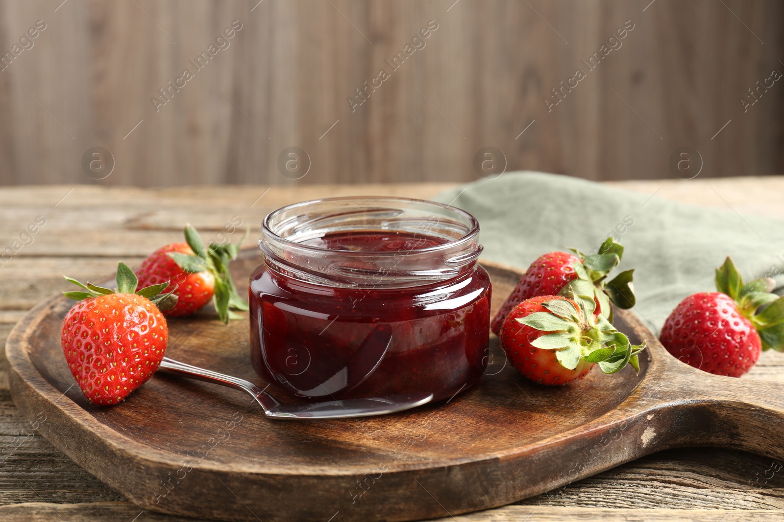 Photo of Delicious strawberry sauce and fresh berries on wooden table