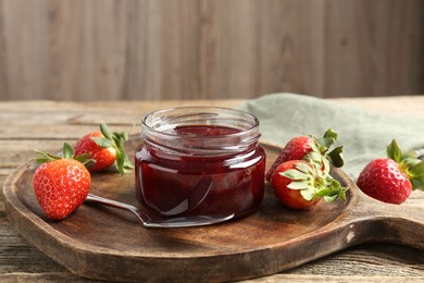 Photo of Delicious strawberry sauce and fresh berries on wooden table