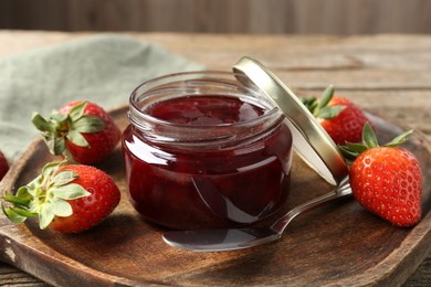 Photo of Delicious strawberry sauce and fresh berries on wooden table, closeup