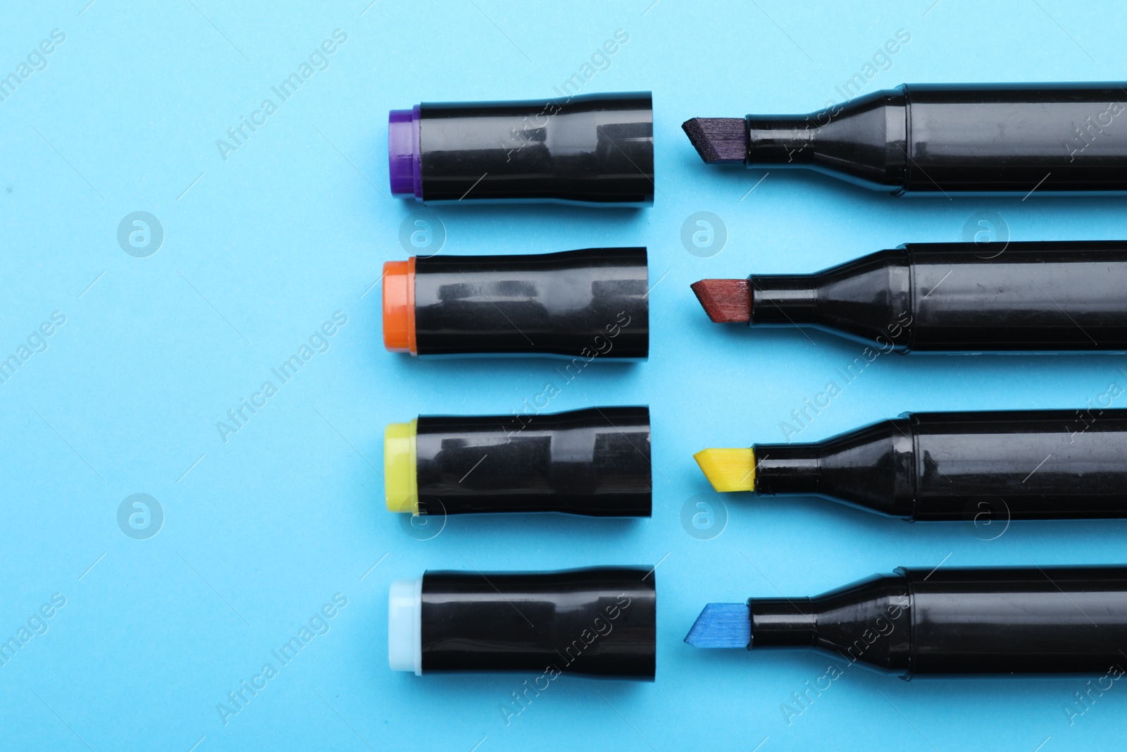 Photo of Colorful markers on light blue background, flat lay