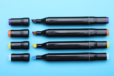 Photo of Colorful double sided markers on light blue background, top view