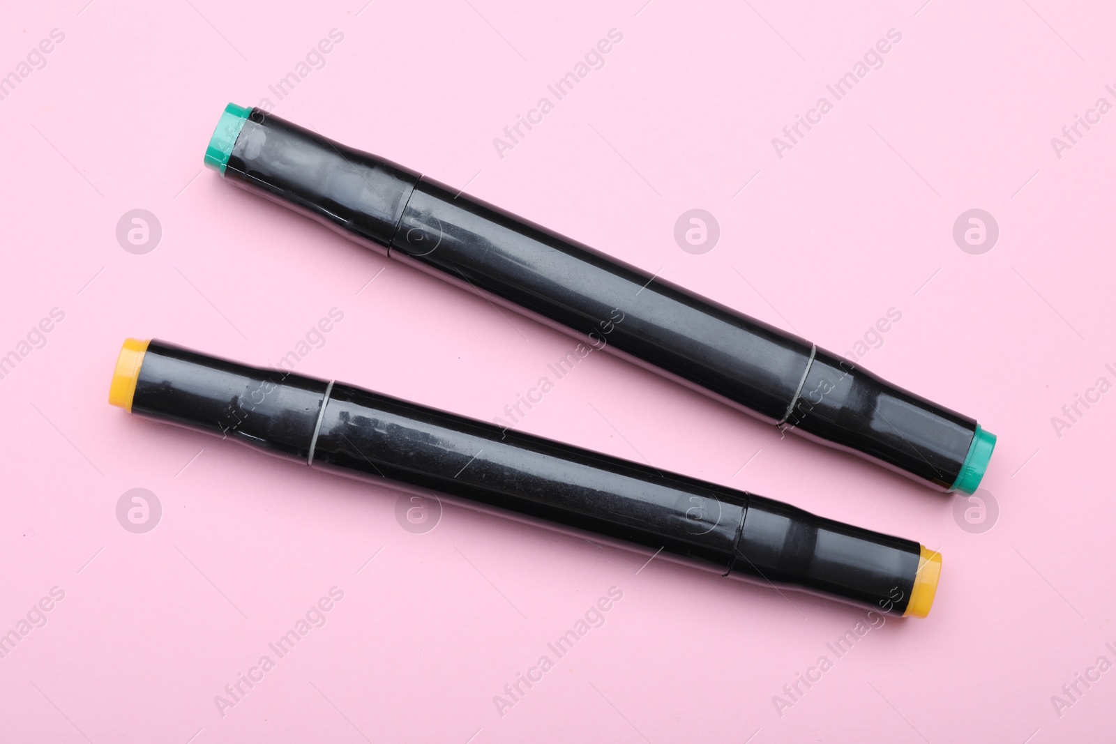 Photo of Two color markers on pink background, top view