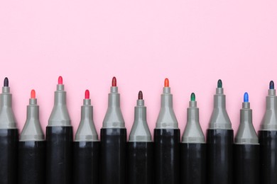 Photo of Colorful markers on light pink background, top view. Space for text