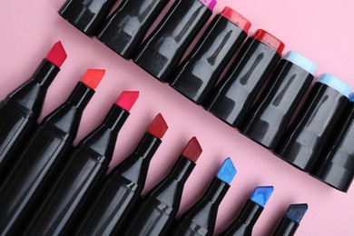 Photo of Colorful markers on light pink background, flat lay