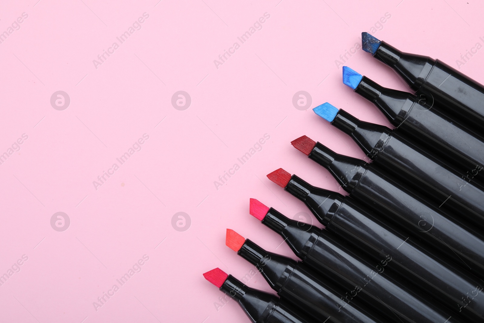 Photo of Colorful markers on light pink background, top view. Space for text