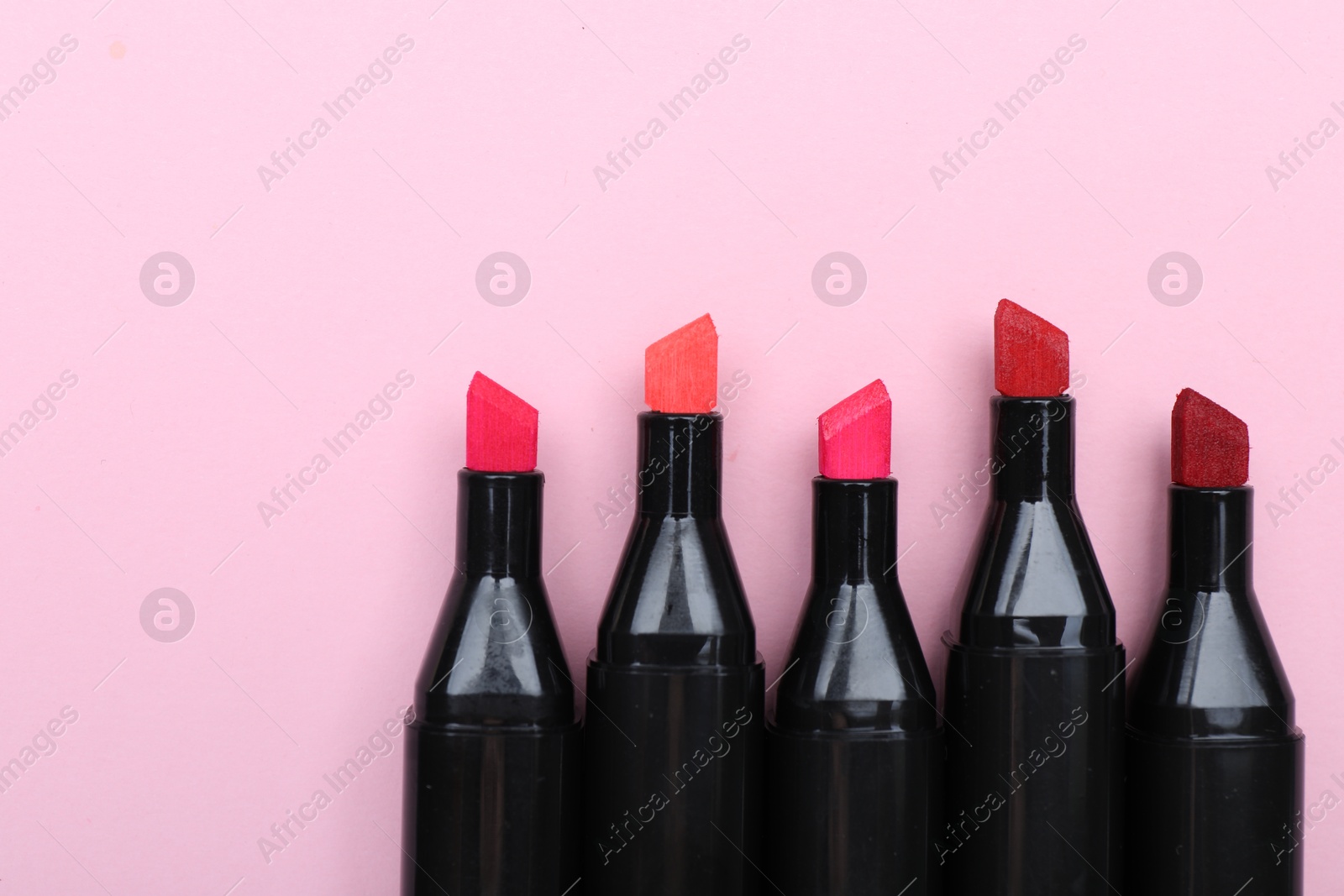 Photo of Colorful markers on light pink background, top view. Space for text