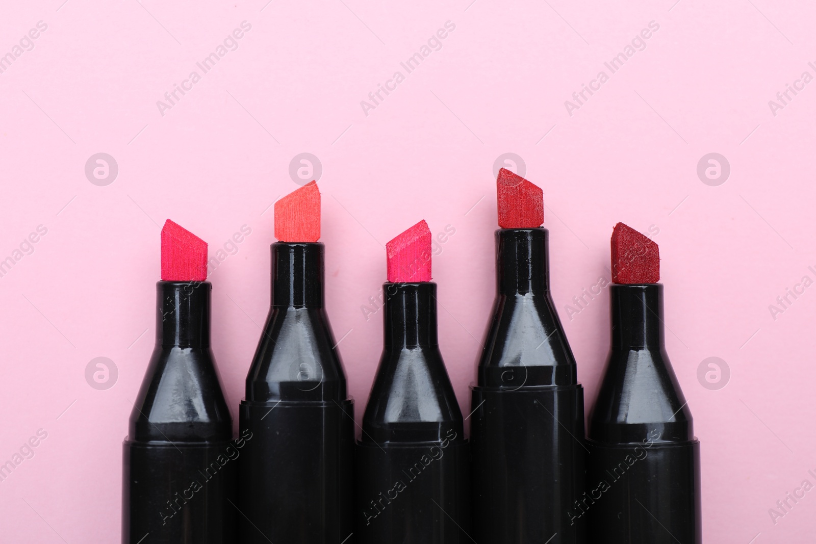 Photo of Colorful markers on light pink background, top view. Space for text