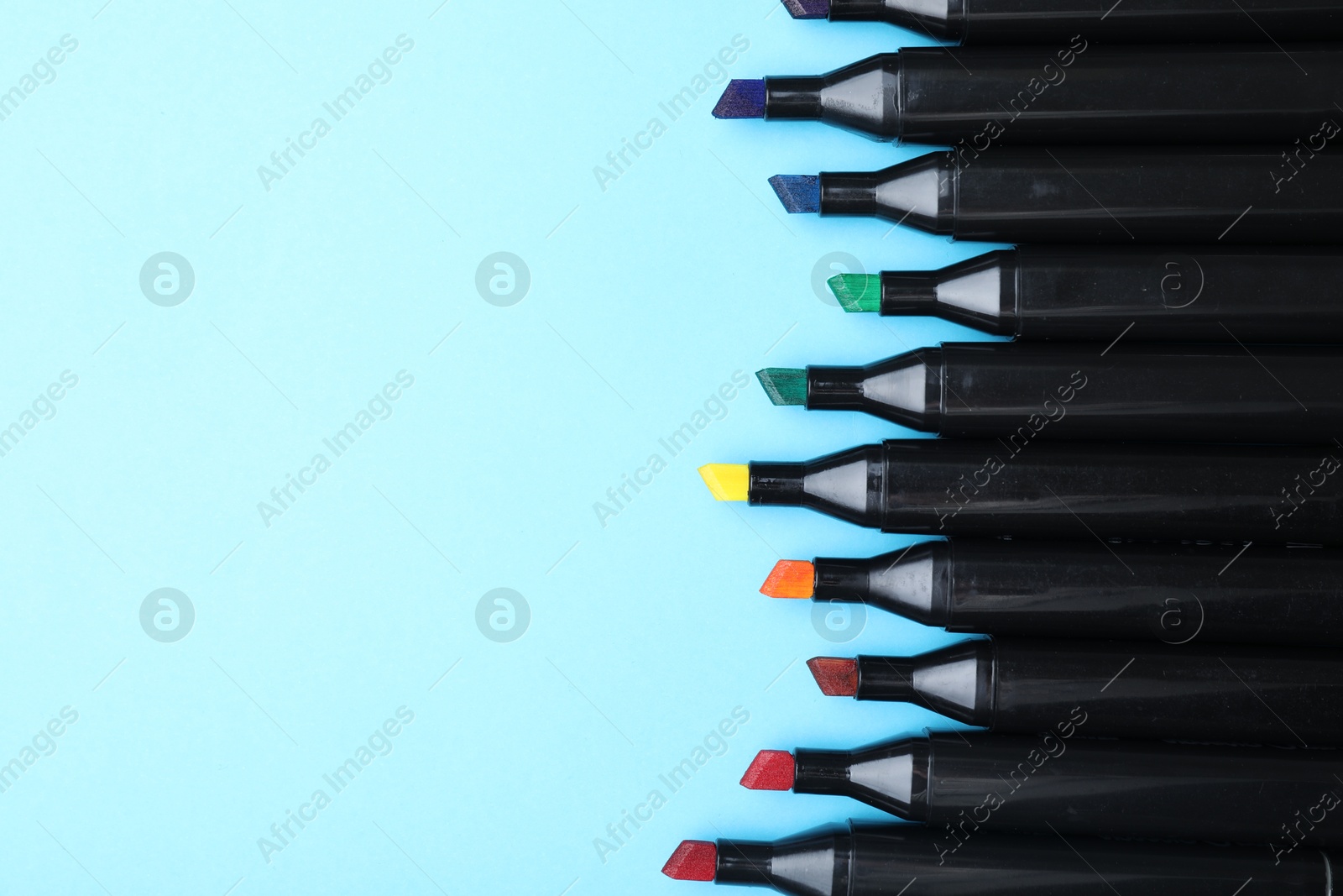 Photo of Colorful markers on light blue background, top view. Space for text