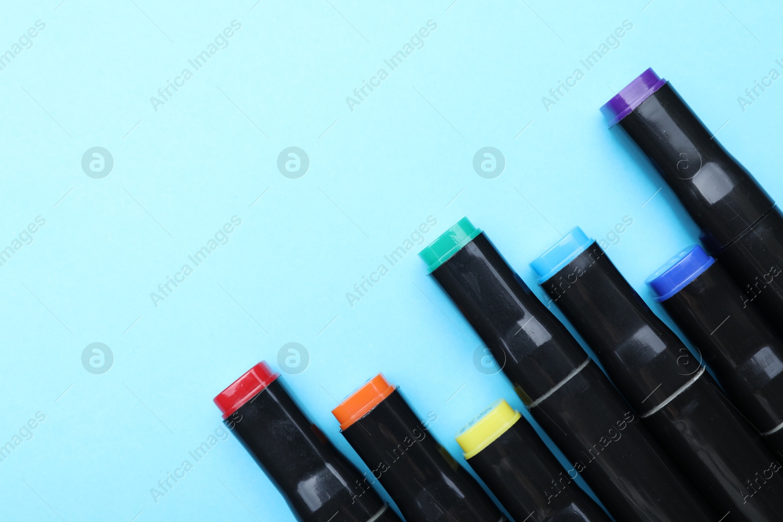 Photo of Colorful markers on light blue background, top view. Space for text