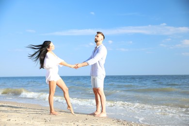 Photo of Lovely young couple at beach on sunny day